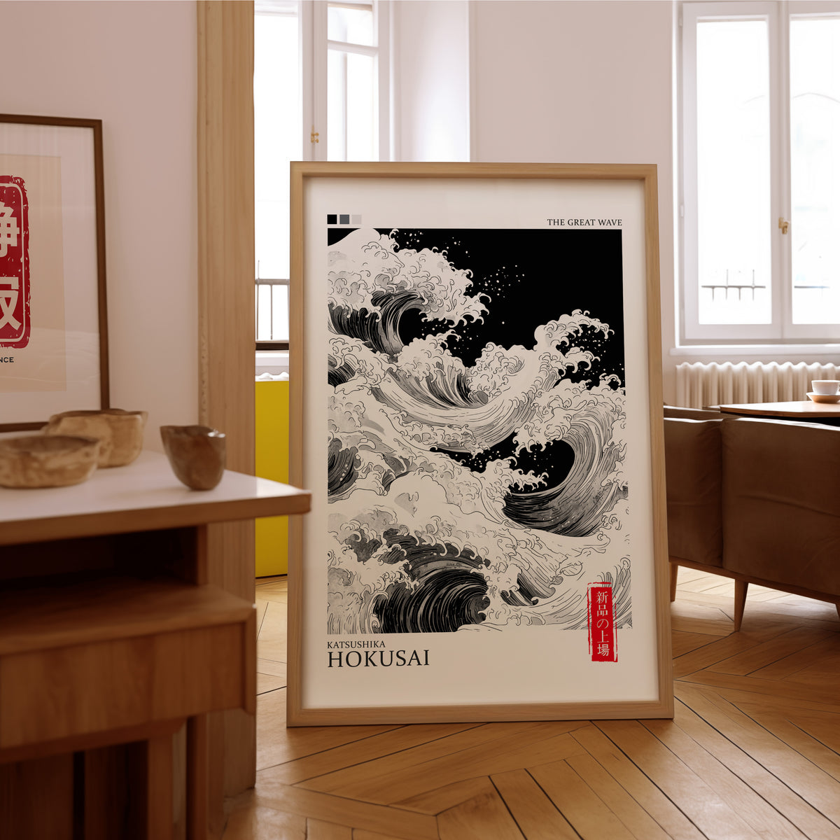 Black and white Great Wave print in an oak frame on the parquet floor of a sunlit living room
