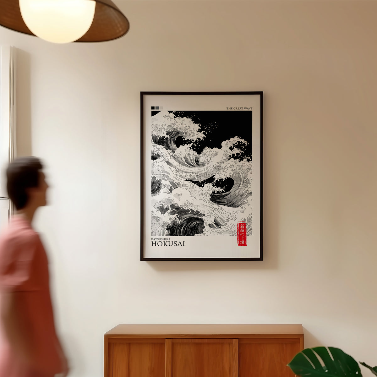 Black and white Great Wave print in a black frame in a hallway under a rattan pendant
