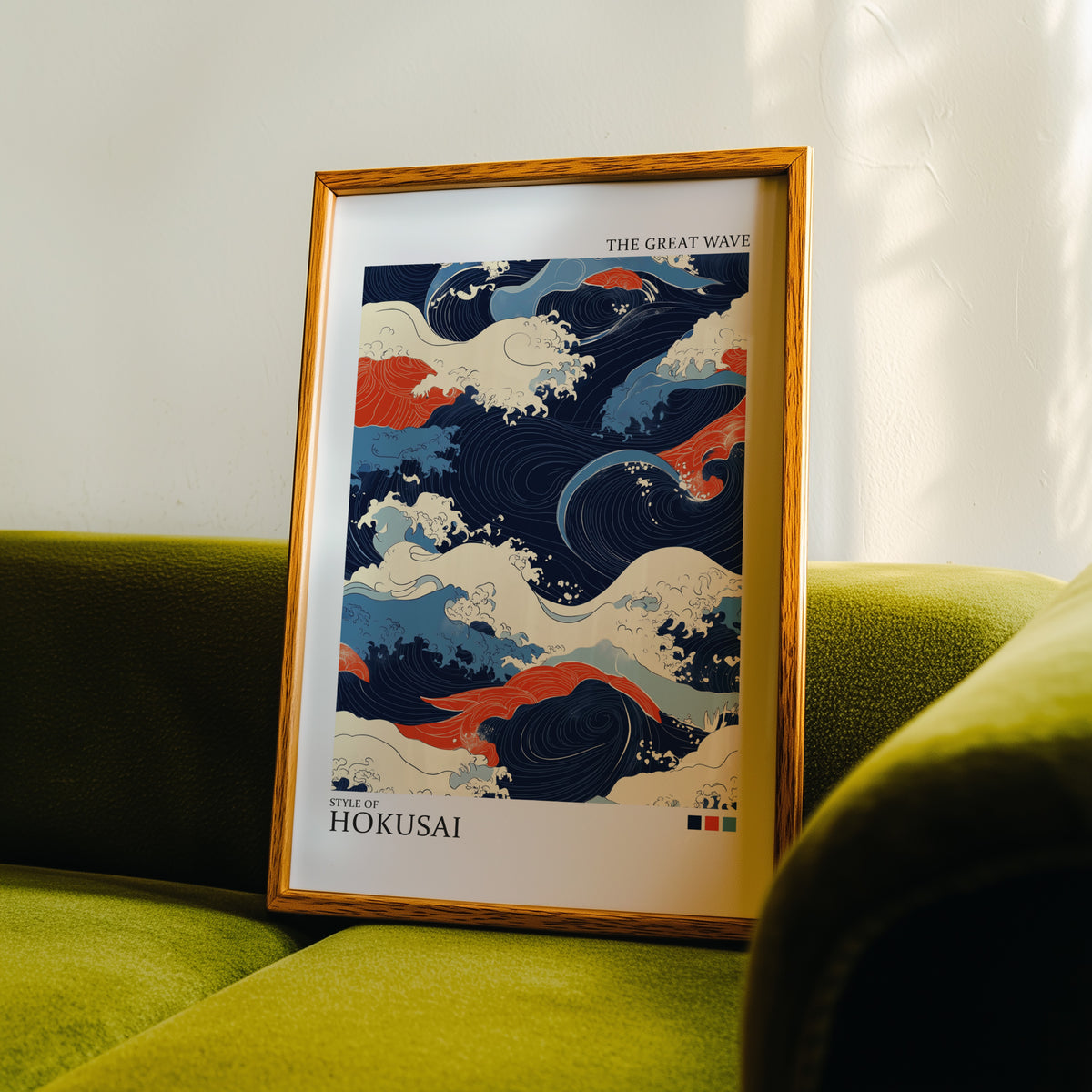 Navy and orange Great Wave print in an oak frame propped on a green velvet sofa