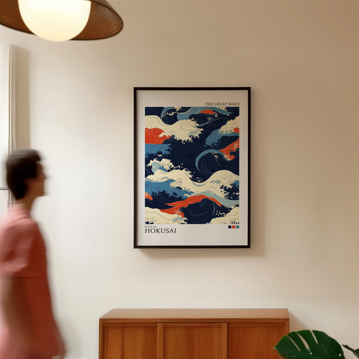 Navy and orange Great Wave print in a black frame in a hallway under a rattan pendant