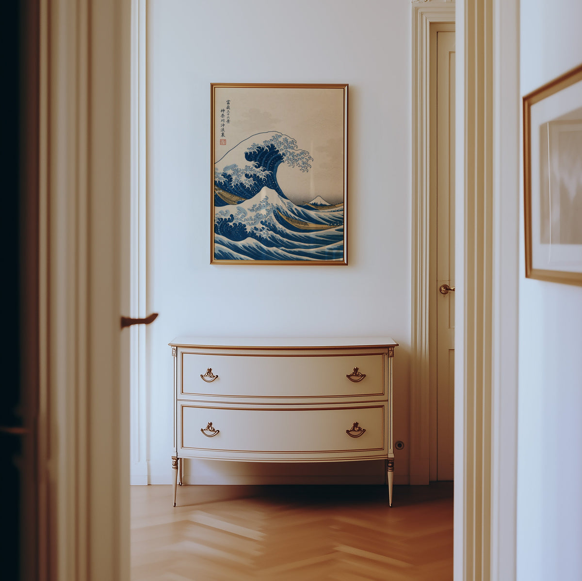 Great Wave off Kanagawa print shown in a gold frame in a hallway above a cream dresser