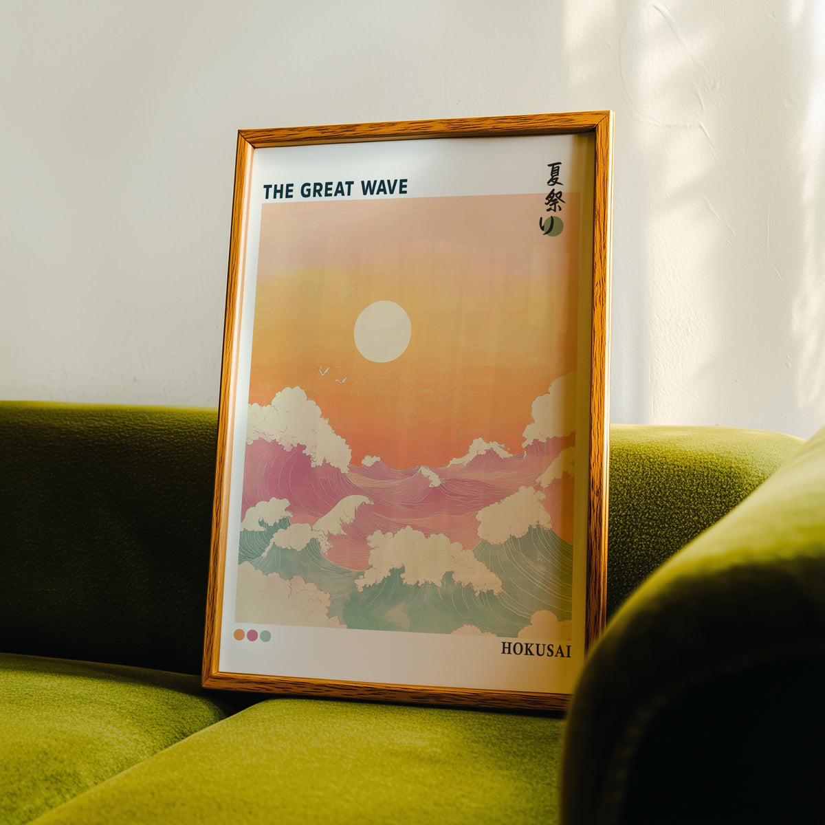 Pastel Great Wave sunset print in an oak frame propped on a green velvet sofa