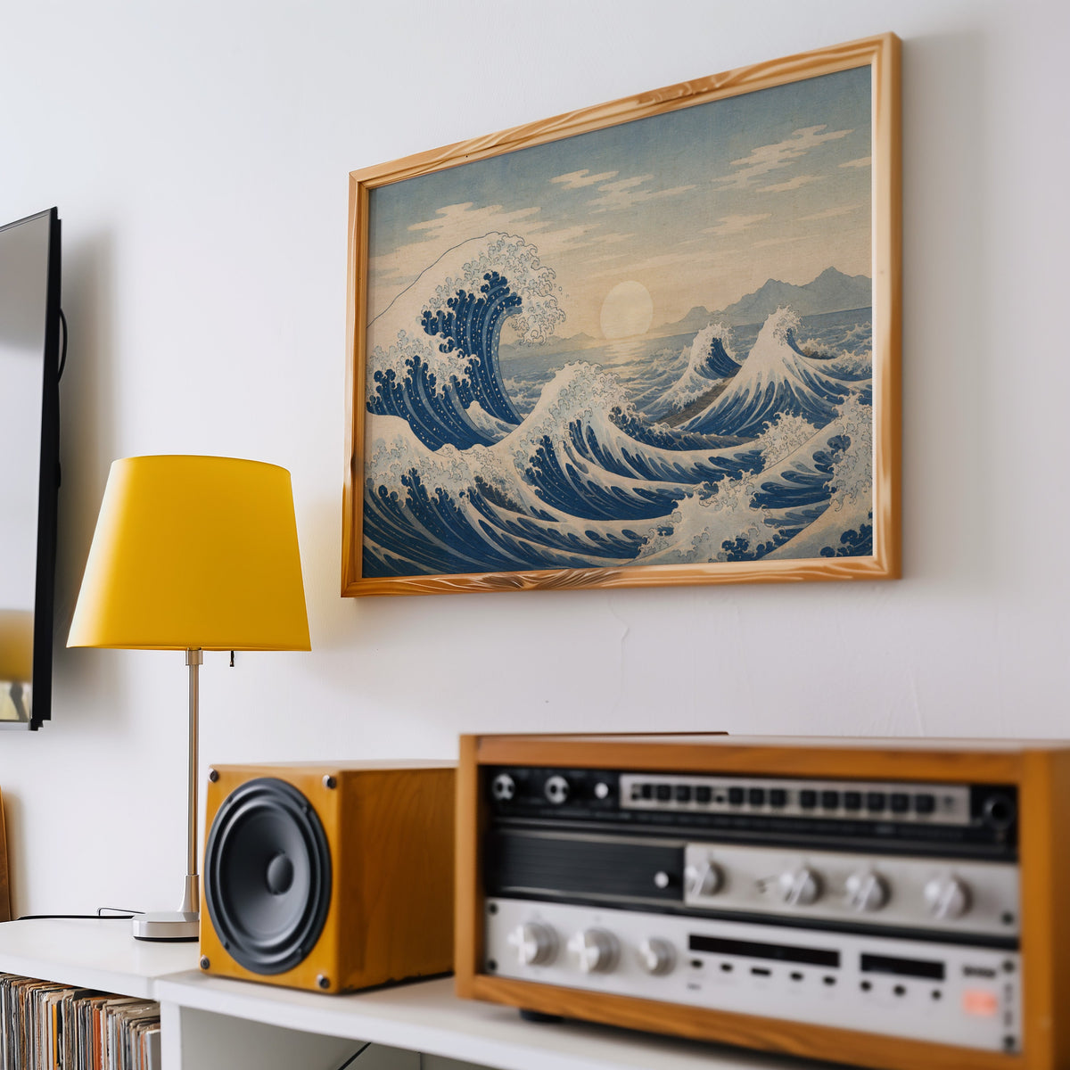 Great wave at sunrise over the sea print in a pine frame above a vintage stereo and a yellow table lamp