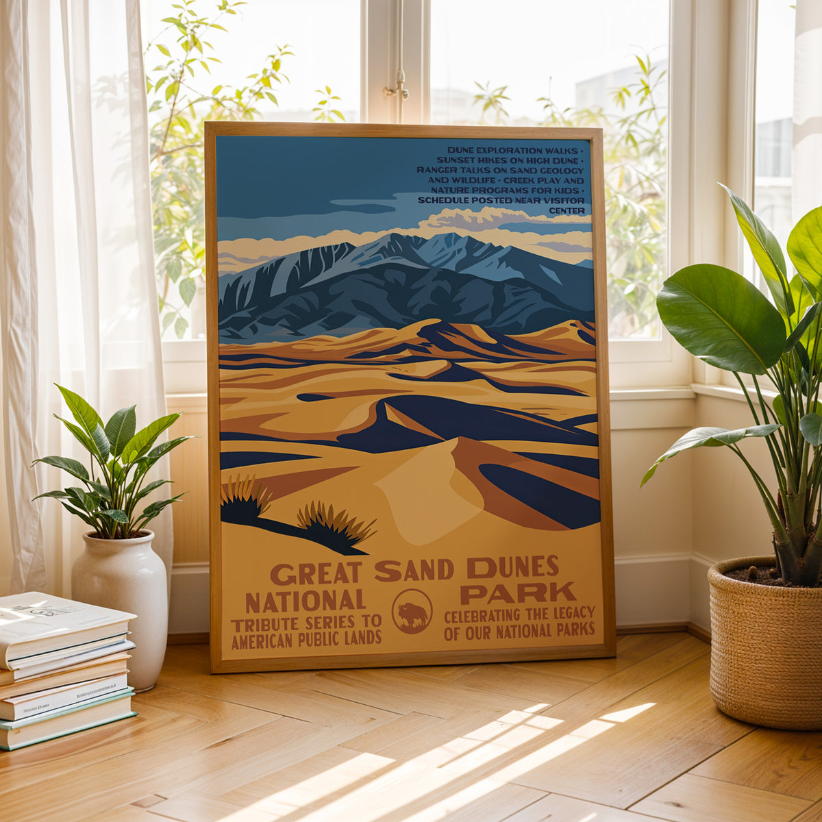 Great Sand Dunes National Park vintage print by a bright window with houseplants and books