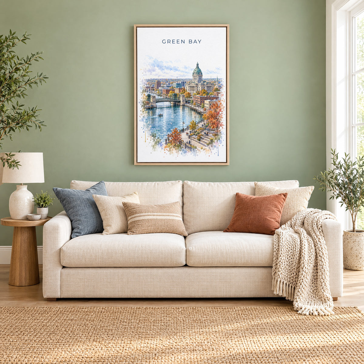 Green Bay watercolor print as a natural floater canvas above a cream linen sofa on a sage green wall