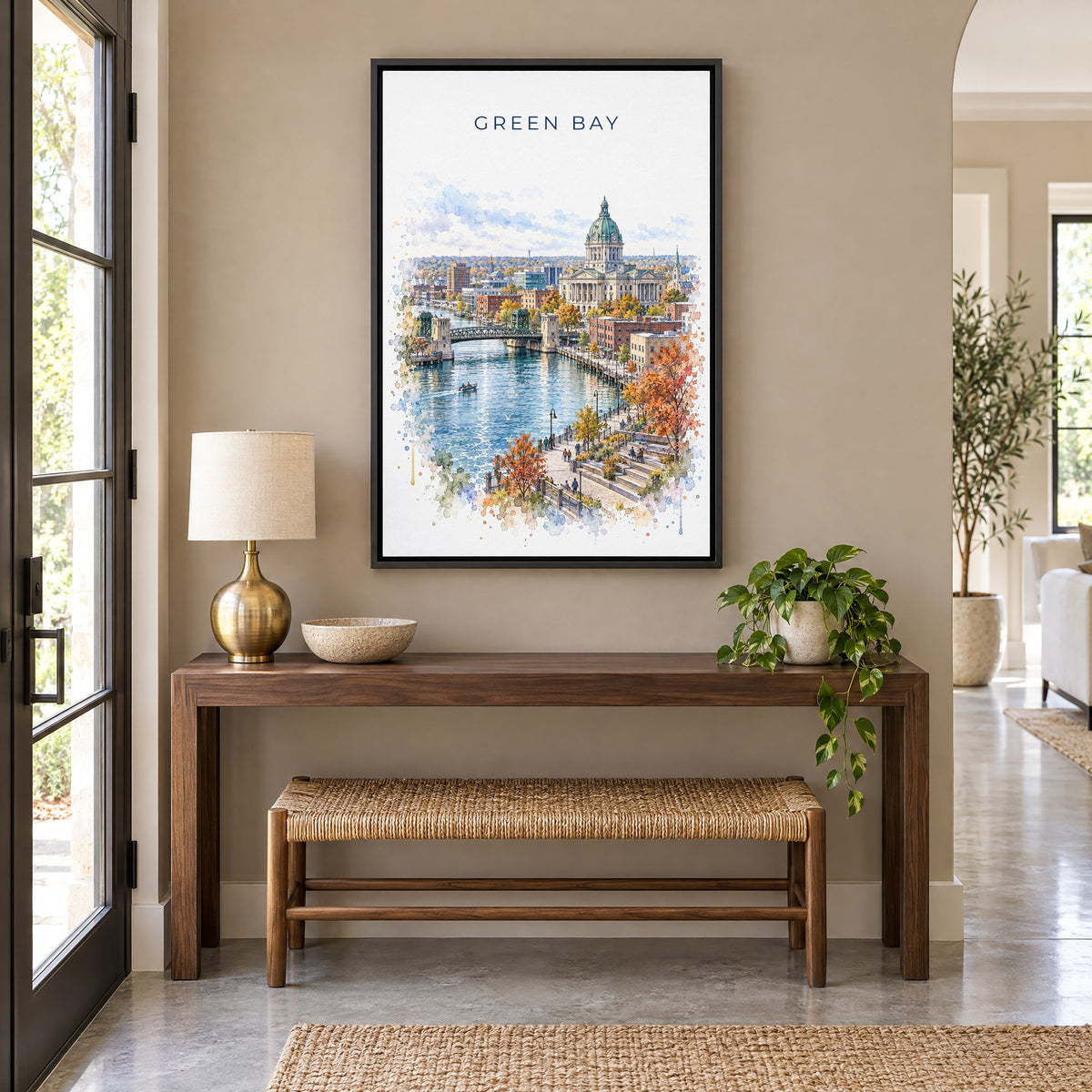 Green Bay watercolor print as a black floater canvas above a walnut console and woven bench in an entryway