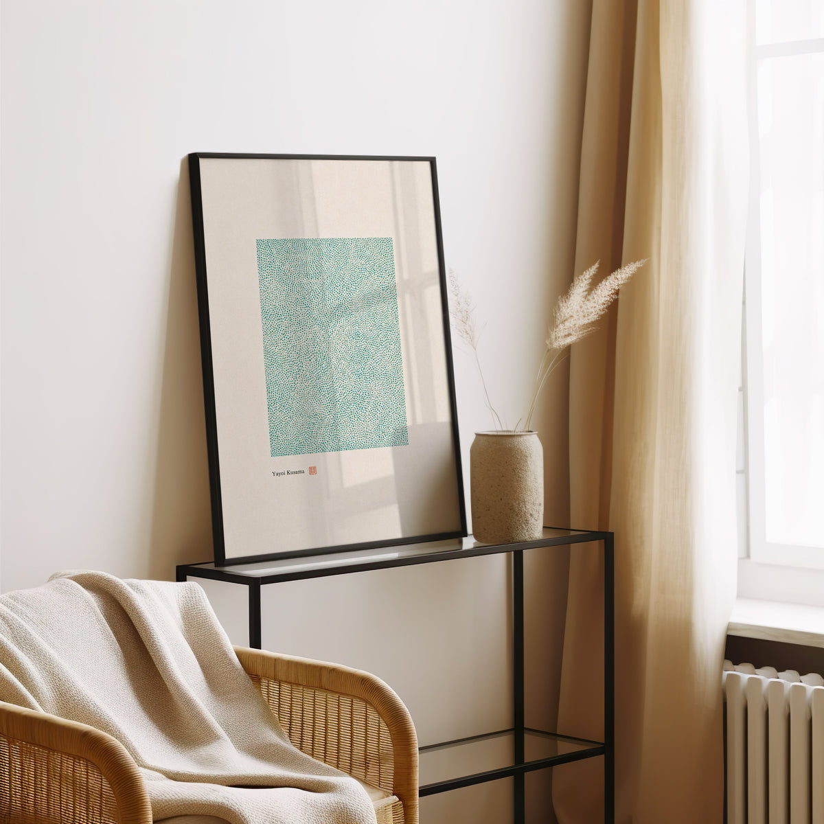 green dot field abstract print in a black frame leaning on a glass console beside pampas grass