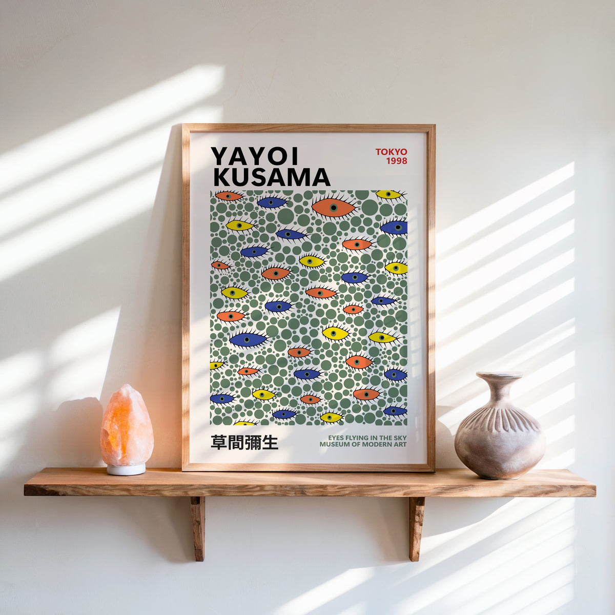 Yayoi Kusama inspired green dots and eyes print above a shelf with a salt lamp