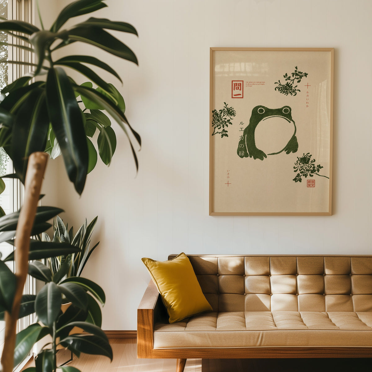 green frog with chrysanthemums print in an oak frame above a tan tufted leather sofa with a mustard cushion