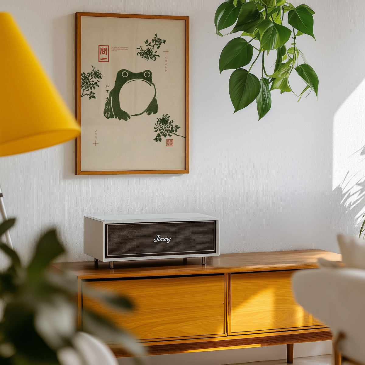 green frog with chrysanthemums print in an oak frame above a teak mid-century sideboard with trailing pothos