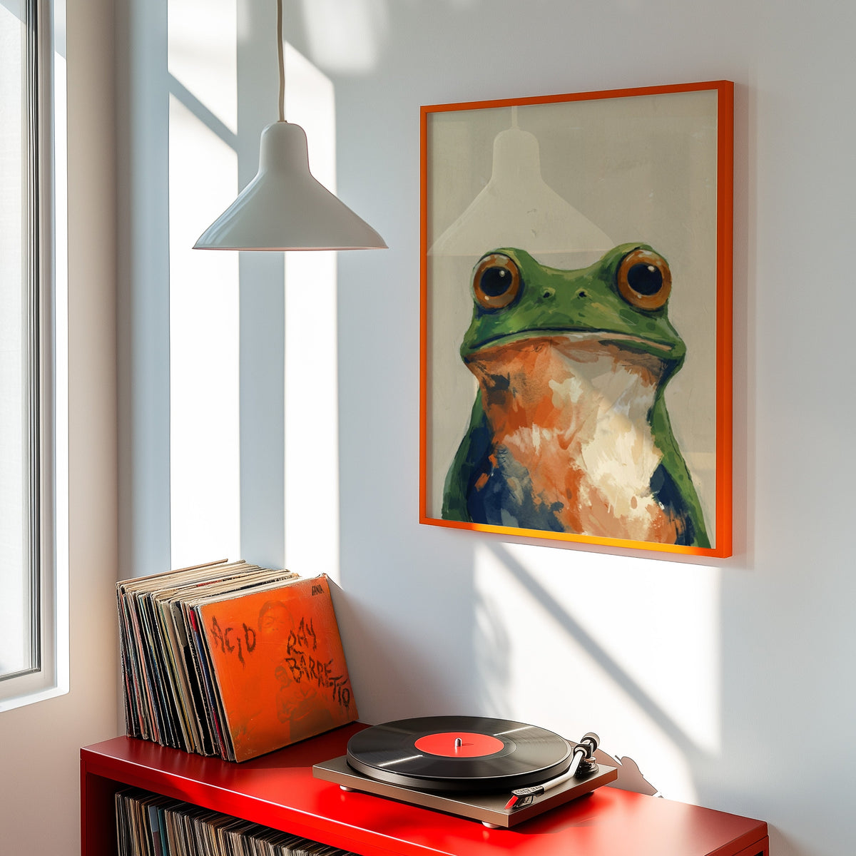 Frog with orange eyes print shown in an orange frame above a red record cabinet and turntable