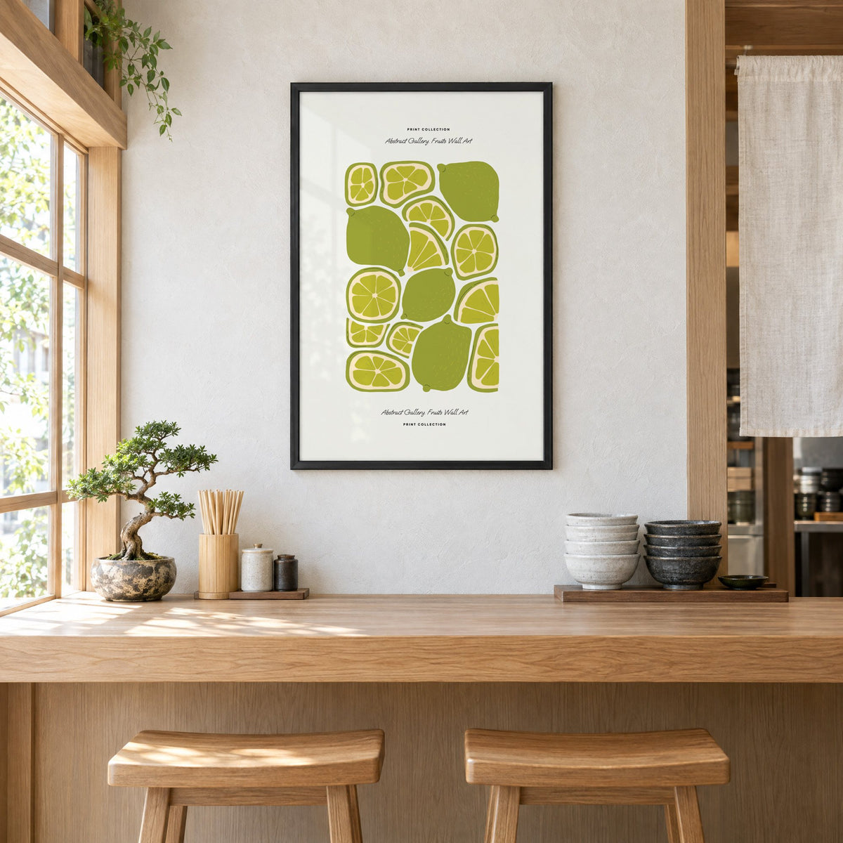 green lime slices pattern fruit print in a black frame above a light wood ramen counter with stools and stacked bowls