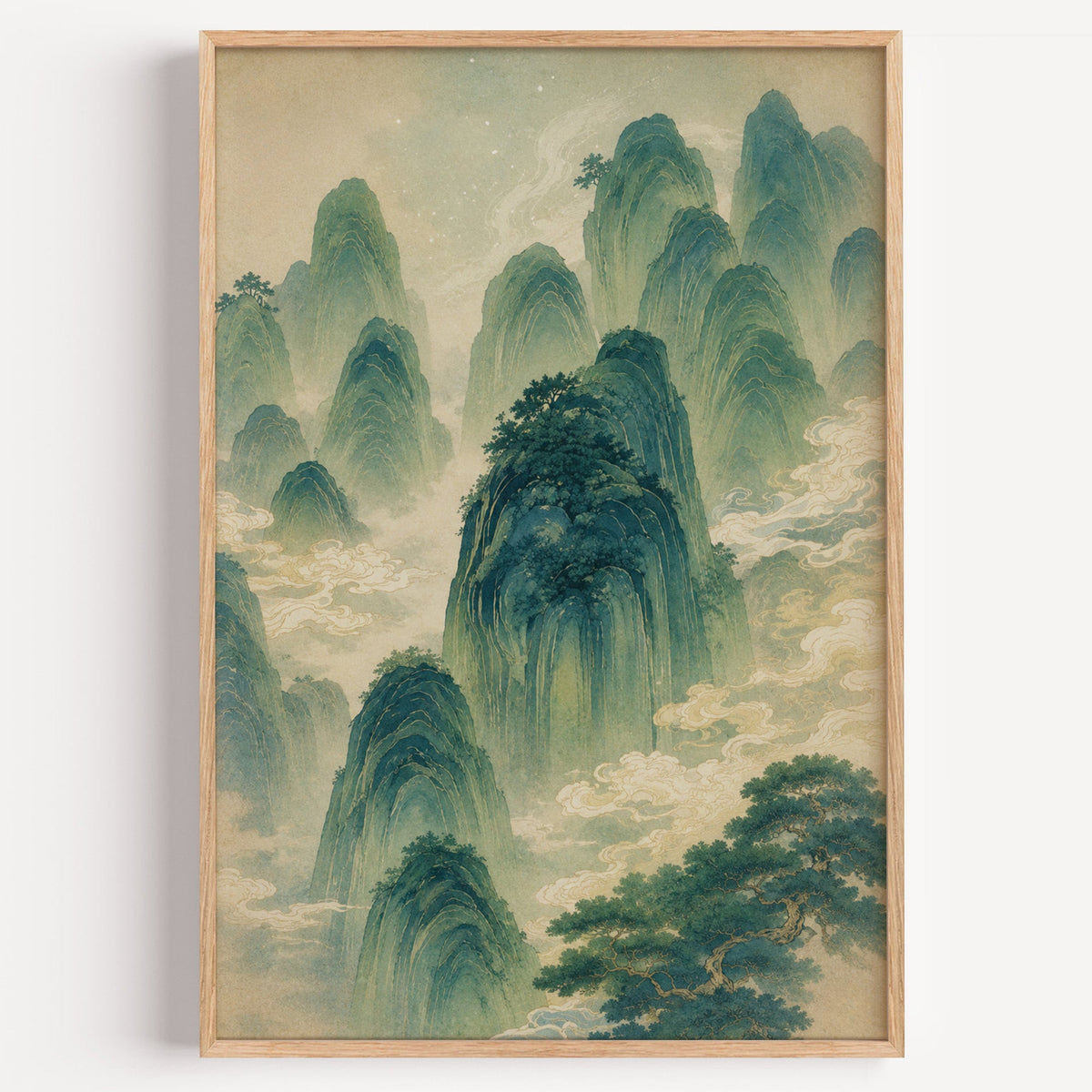 green mountains and clouds landscape print in a light oak frame on a plain white wall