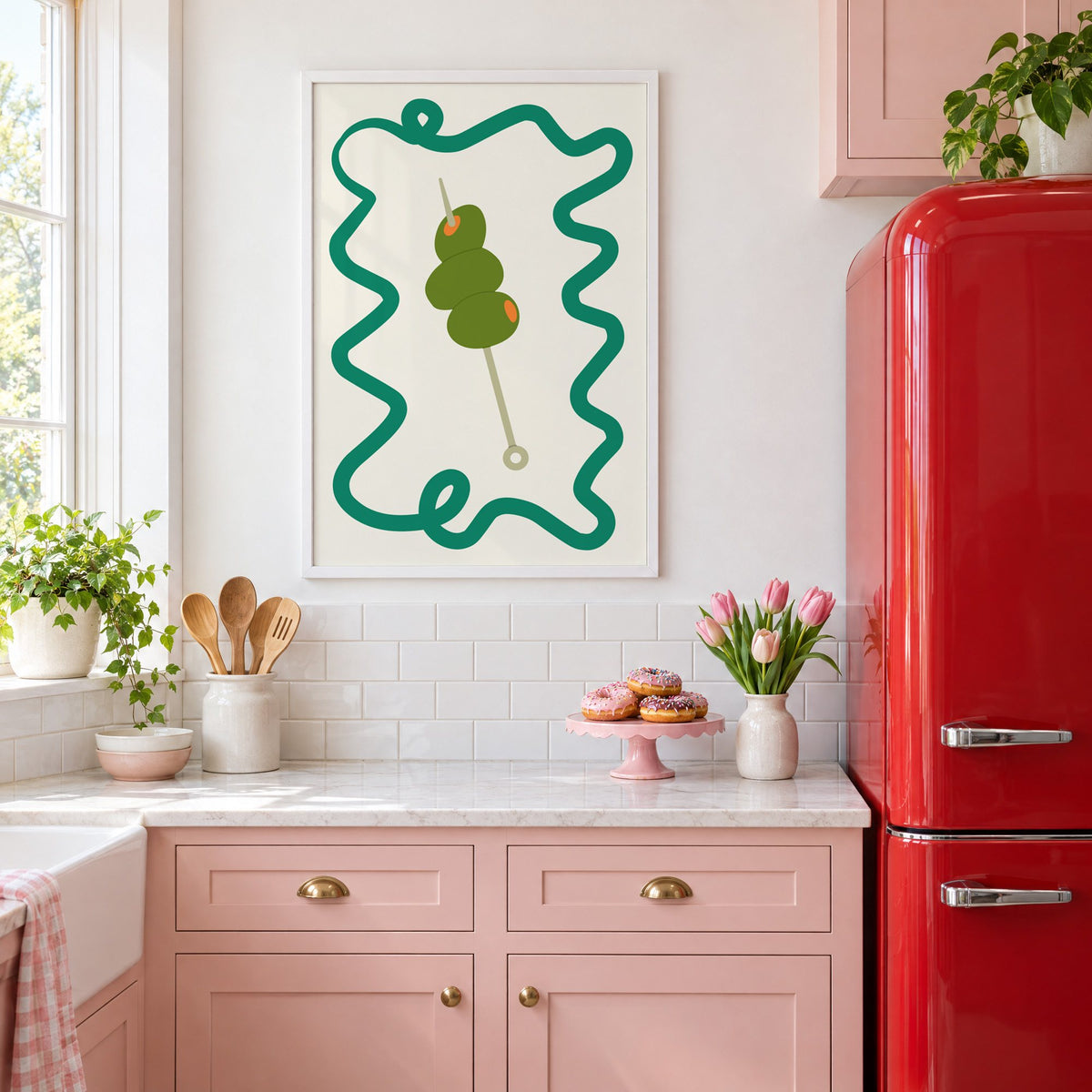Green olives cocktail pick print in a white frame in a pink kitchen beside a red retro fridge