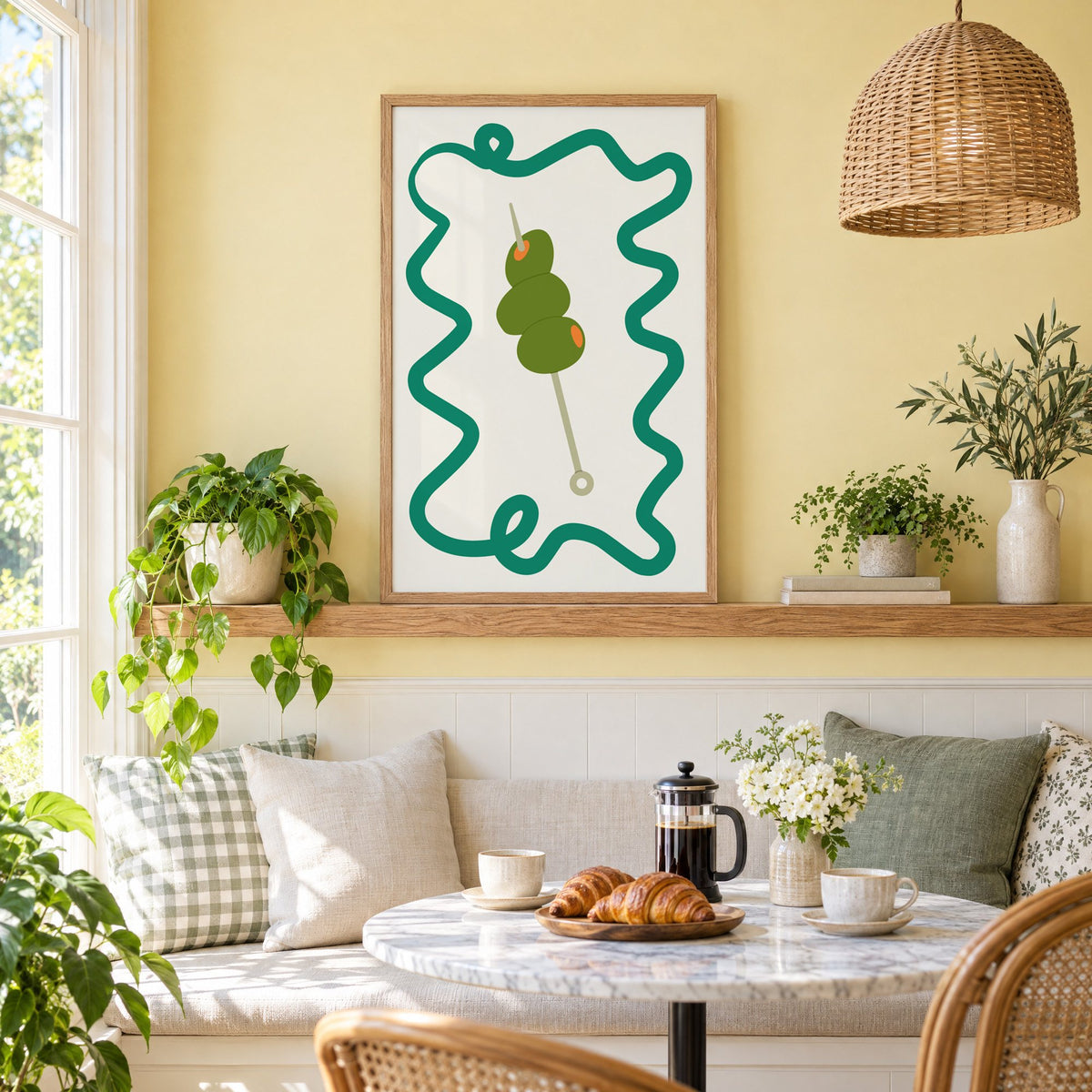 Green olives cocktail pick print in an oak frame on a picture ledge above a sunny breakfast nook