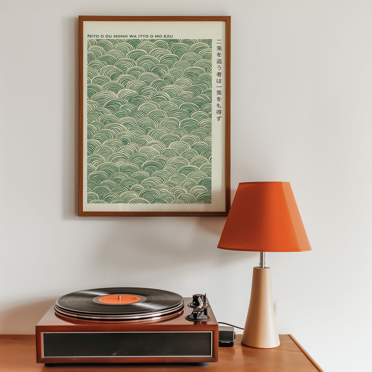 Green seigaiha wave proverb print in a walnut frame above a sideboard with a record player