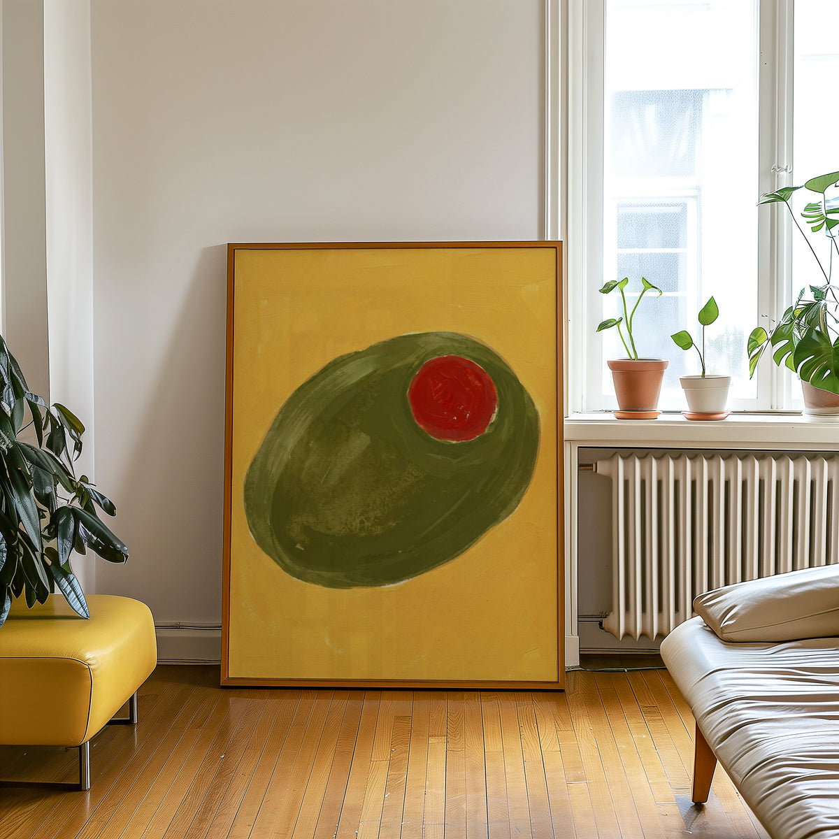 Giant olive still life print in an oak frame leaning beside a yellow leather bench
