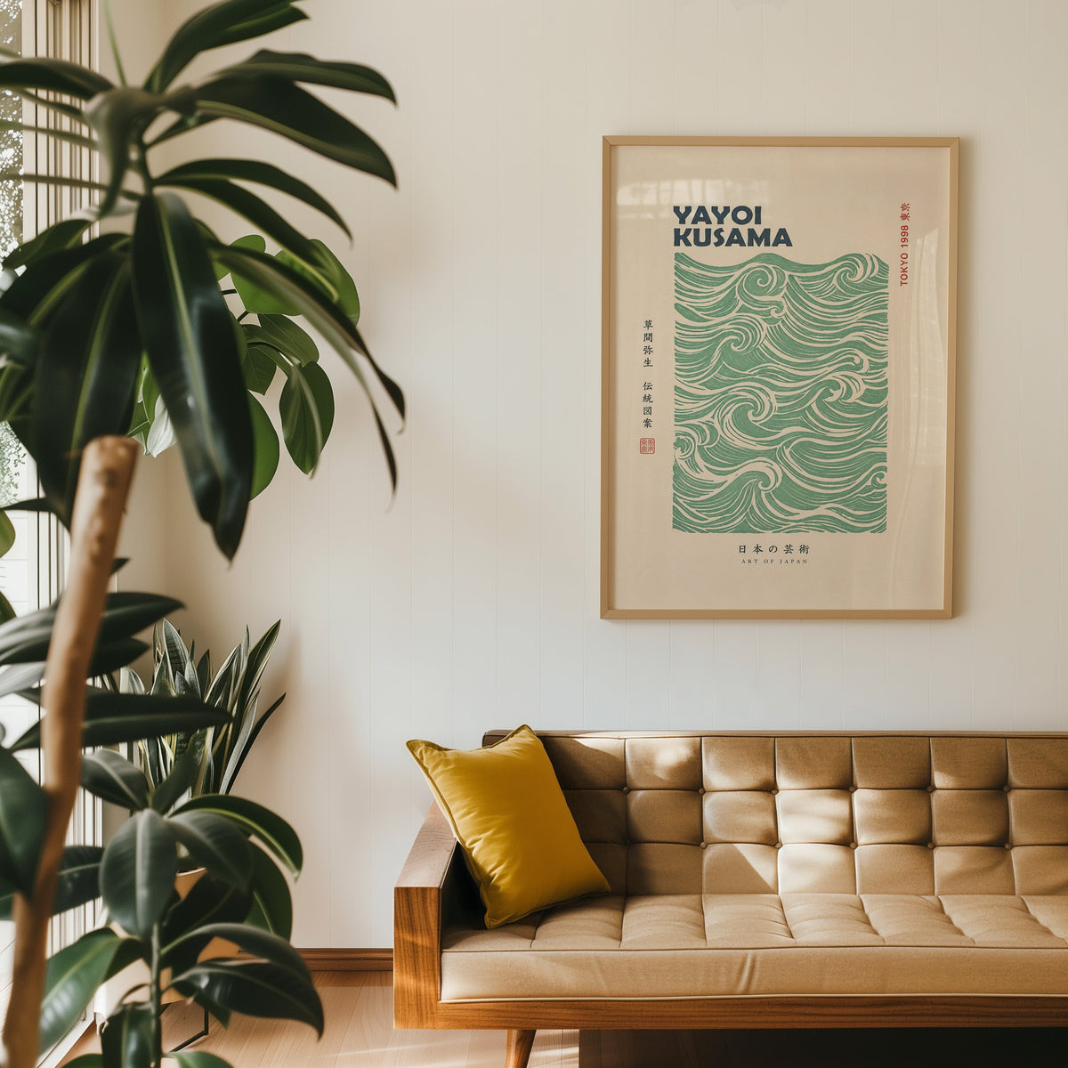 green wave pattern with bold type print in an oak frame above a tan tufted leather sofa with a mustard cushion