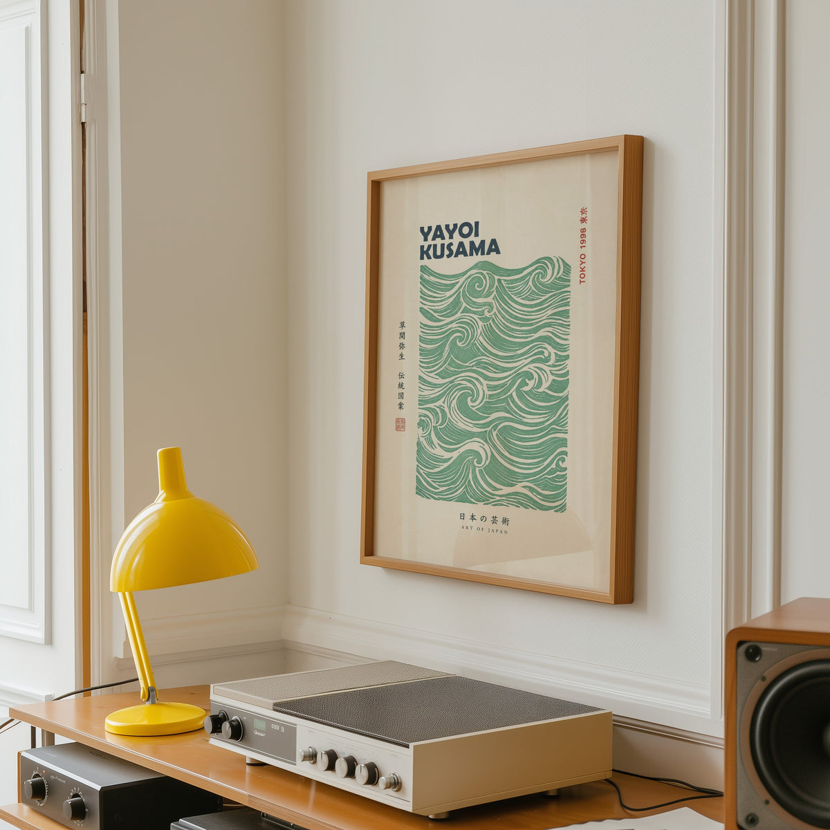 green wave pattern with bold type print in an oak frame above a vintage hi-fi shelf with a yellow desk lamp