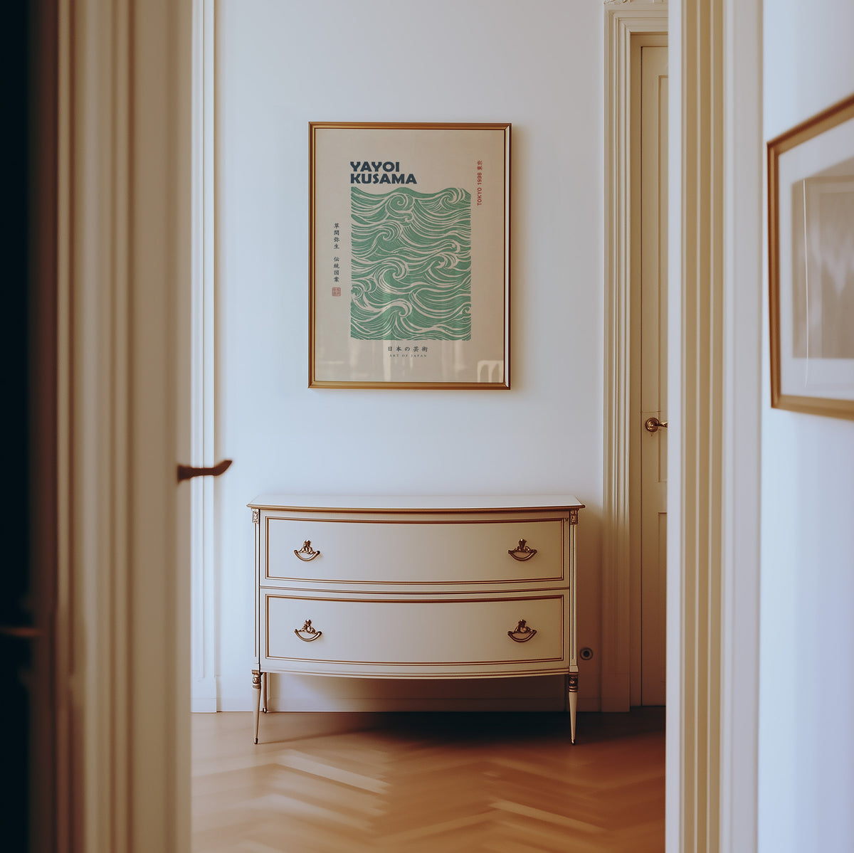 green wave pattern with bold type print shown in a gold frame in a hallway above a cream dresser