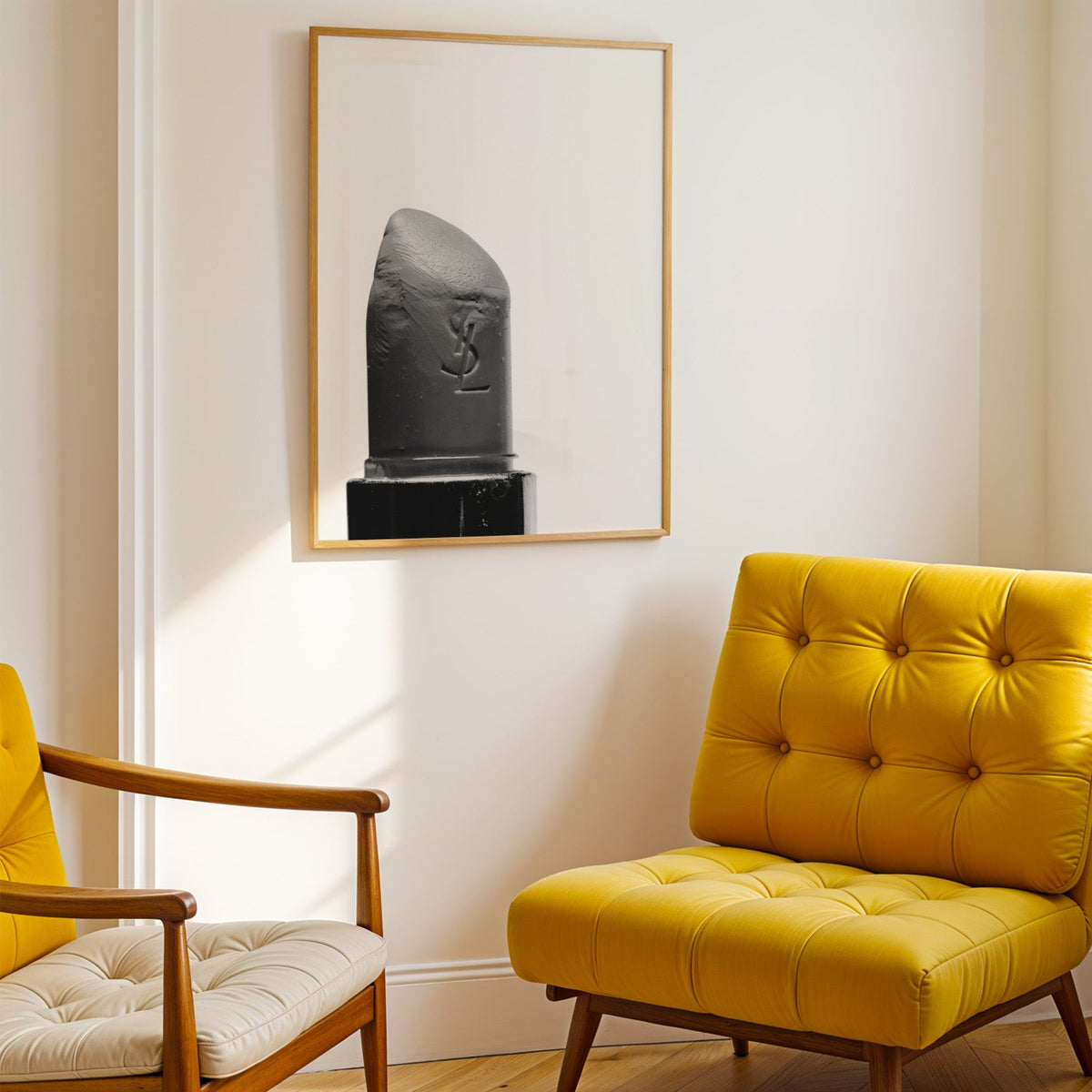 Angled lipstick bullet on plain white print shown in a gold frame above a mustard yellow tufted armchair