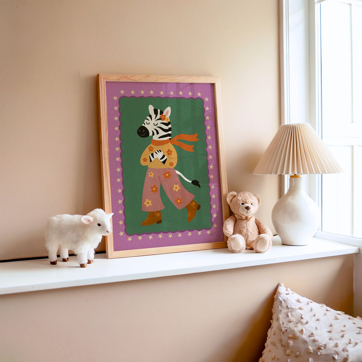 Groovy zebra in flower pants nursery print in an oak frame on a window ledge with a toy lamb and teddy