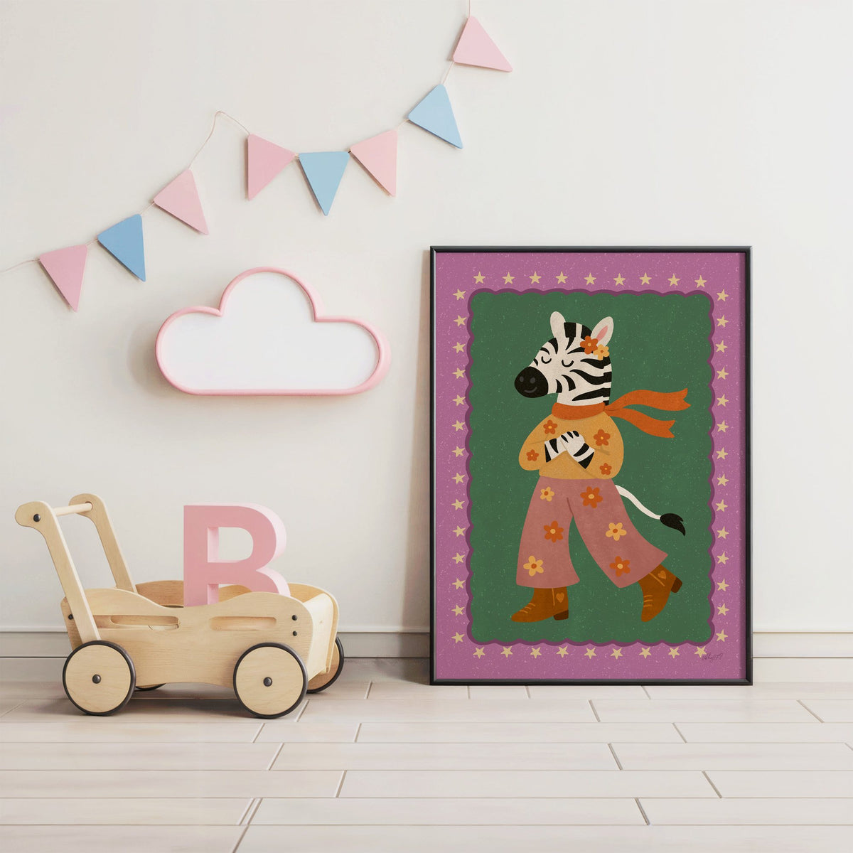 Groovy zebra in flower pants nursery print in a black frame under pastel bunting by a wooden baby walker