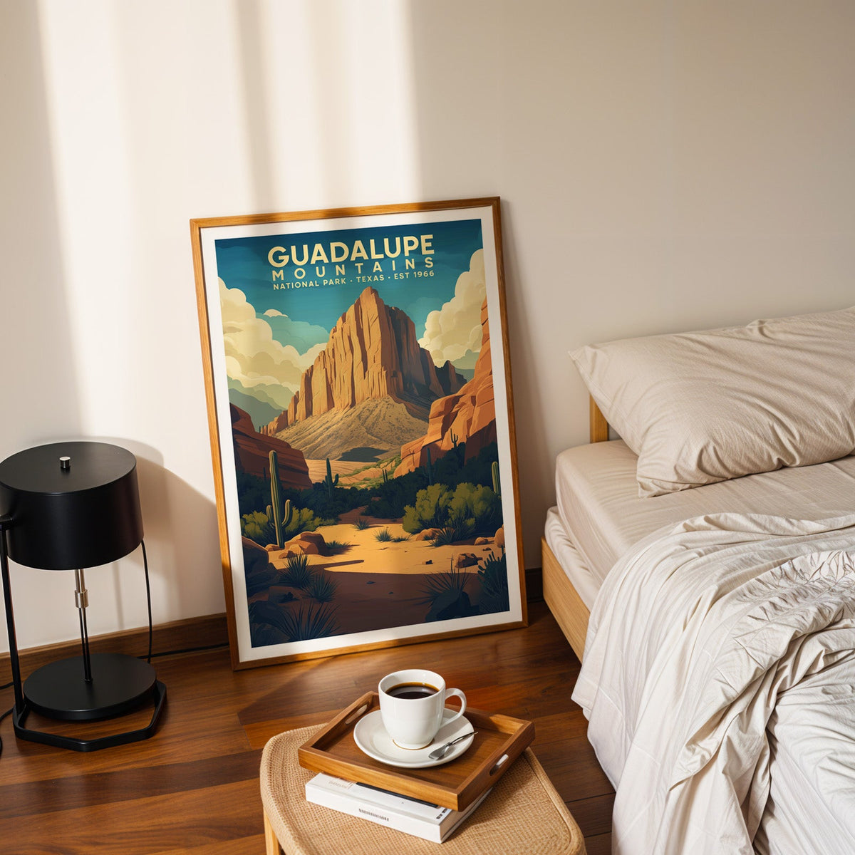 Guadalupe Mountains print in an oak frame leaning on a bedroom floor beside the bed