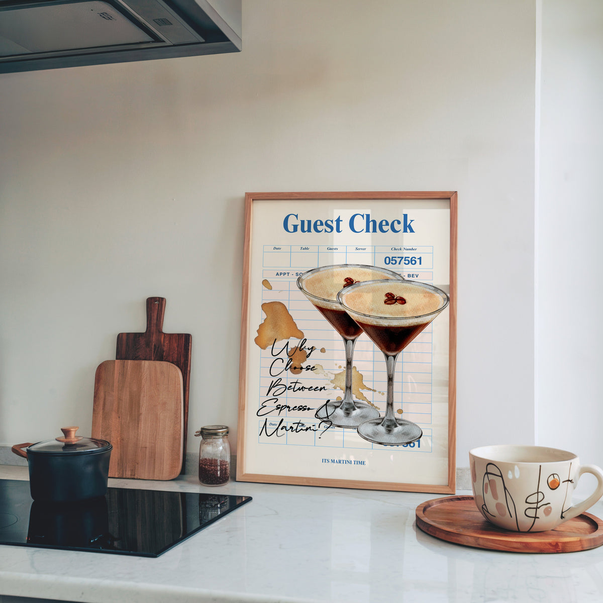 Guest check espresso martini print in a pine frame leaning on a marble kitchen counter beside chopping boards