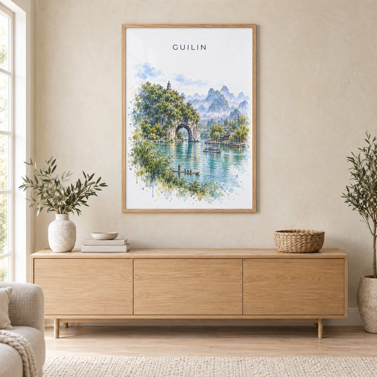 Guilin watercolor print in an oak frame above a light wood sideboard in a Scandinavian living room