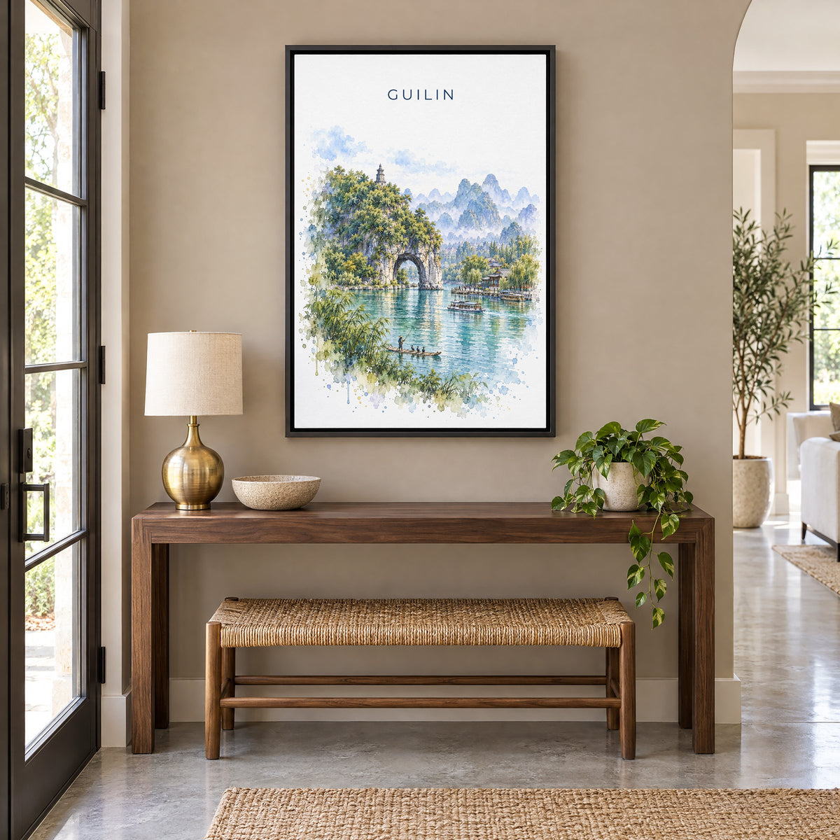 Guilin watercolor print as a black floater canvas above a walnut console and woven bench in an entryway