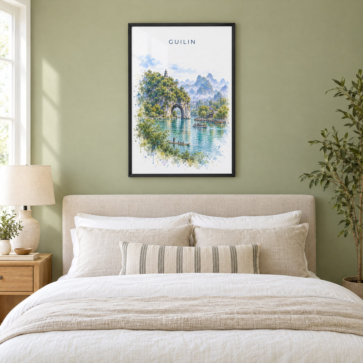 Guilin watercolor print in a black frame above an upholstered headboard in a sage green bedroom
