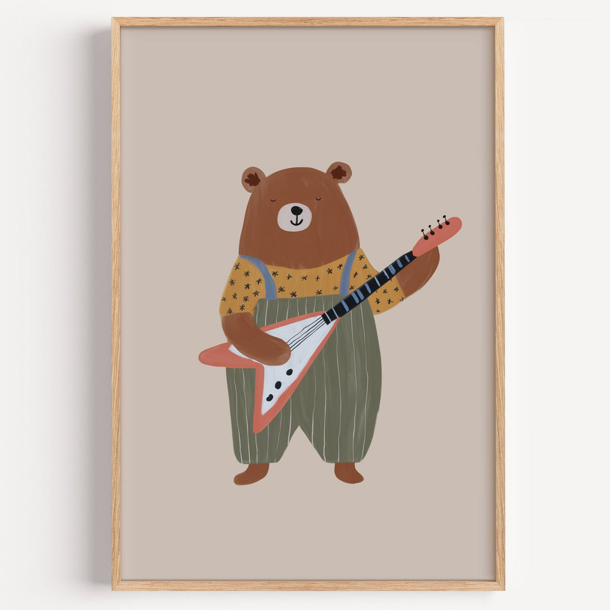 Guitar bear green overalls nursery print in a light oak frame on a plain white wall
