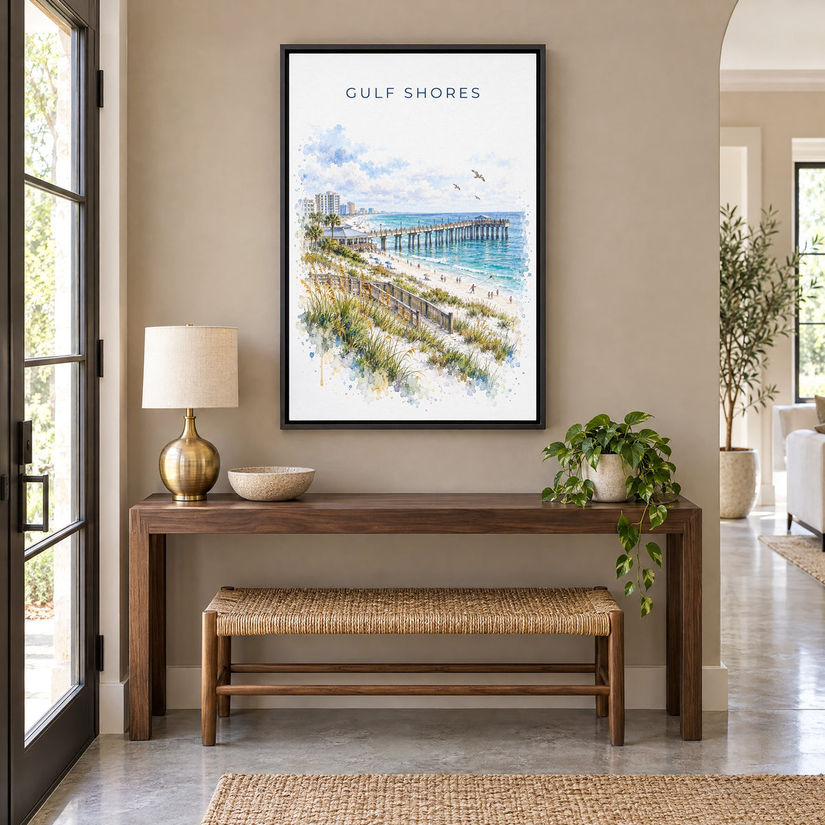 Gulf Shores watercolor print as a black floater canvas above a walnut console and woven bench in an entryway