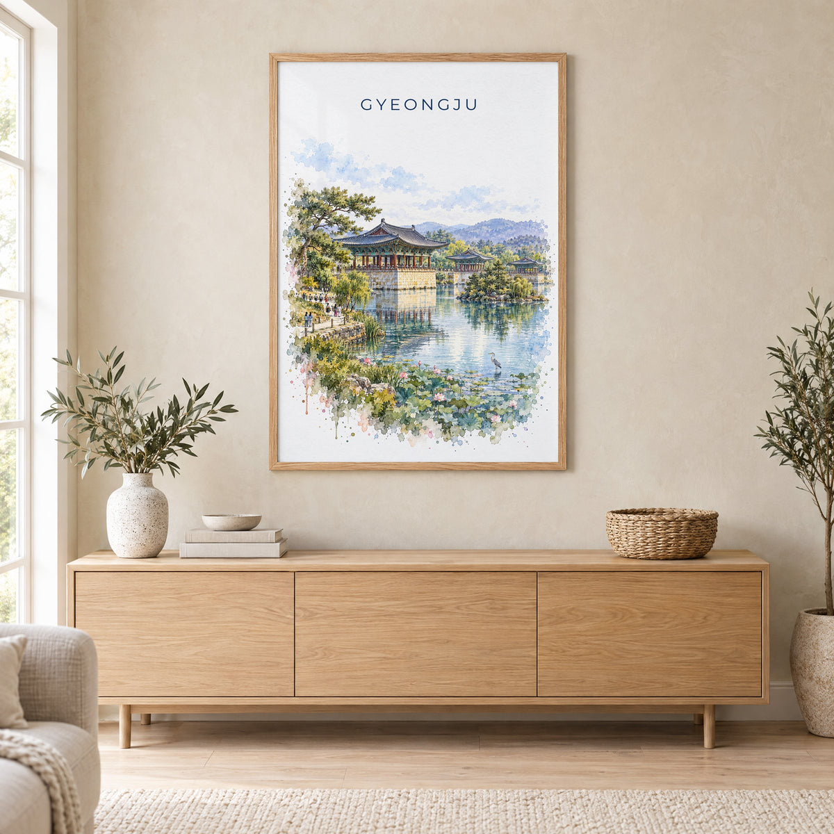 Gyeongju watercolor print in an oak frame above a light wood sideboard in a Scandinavian living room