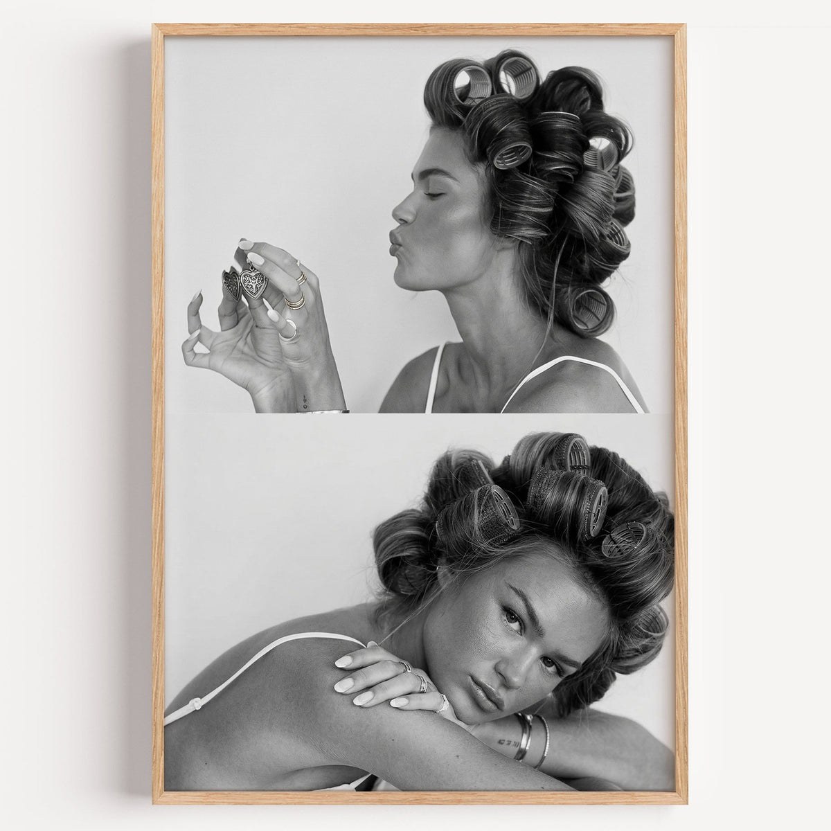 Woman in hair rollers with heart locket two frames print in a light oak frame on a plain white wall