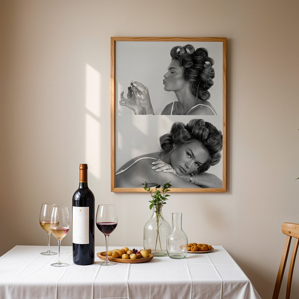 Woman in hair rollers with heart locket two frames print in an oak frame above a table set with red wine and glasses