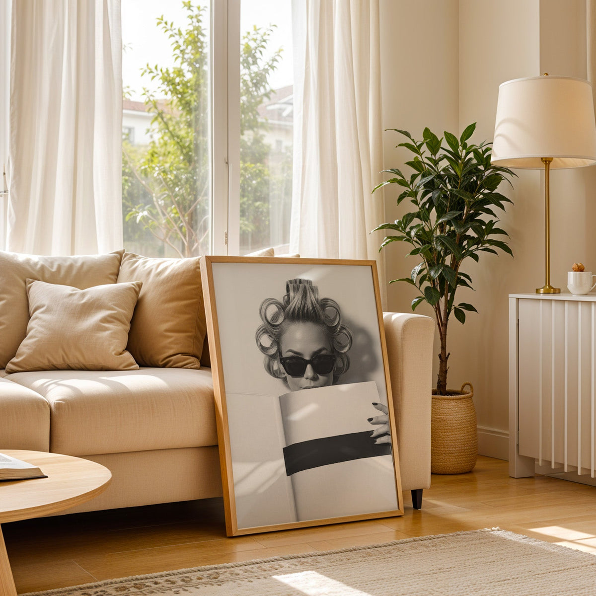 Woman in hair rollers and sunglasses with page print in a light oak frame leaning on a cream sofa beside a floor lamp