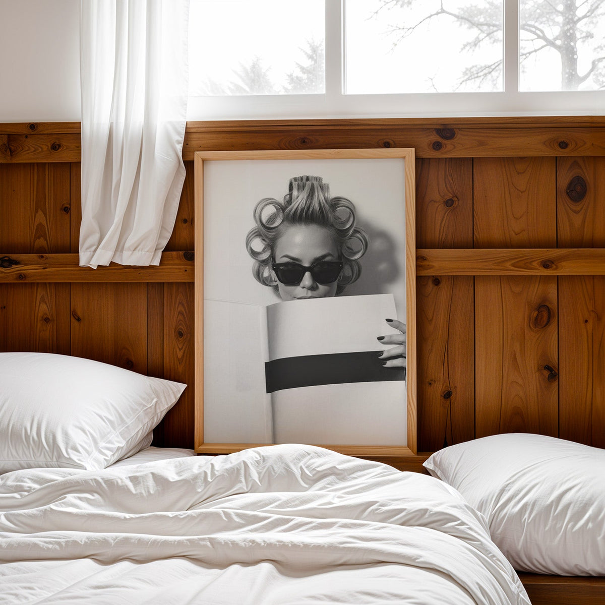 Woman in hair rollers and sunglasses with page print in a pine frame leaning on a wood headboard over white bedding
