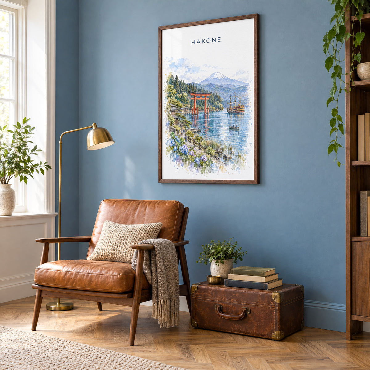 Hakone watercolor print in a walnut frame on a blue wall above a leather armchair in a reading nook