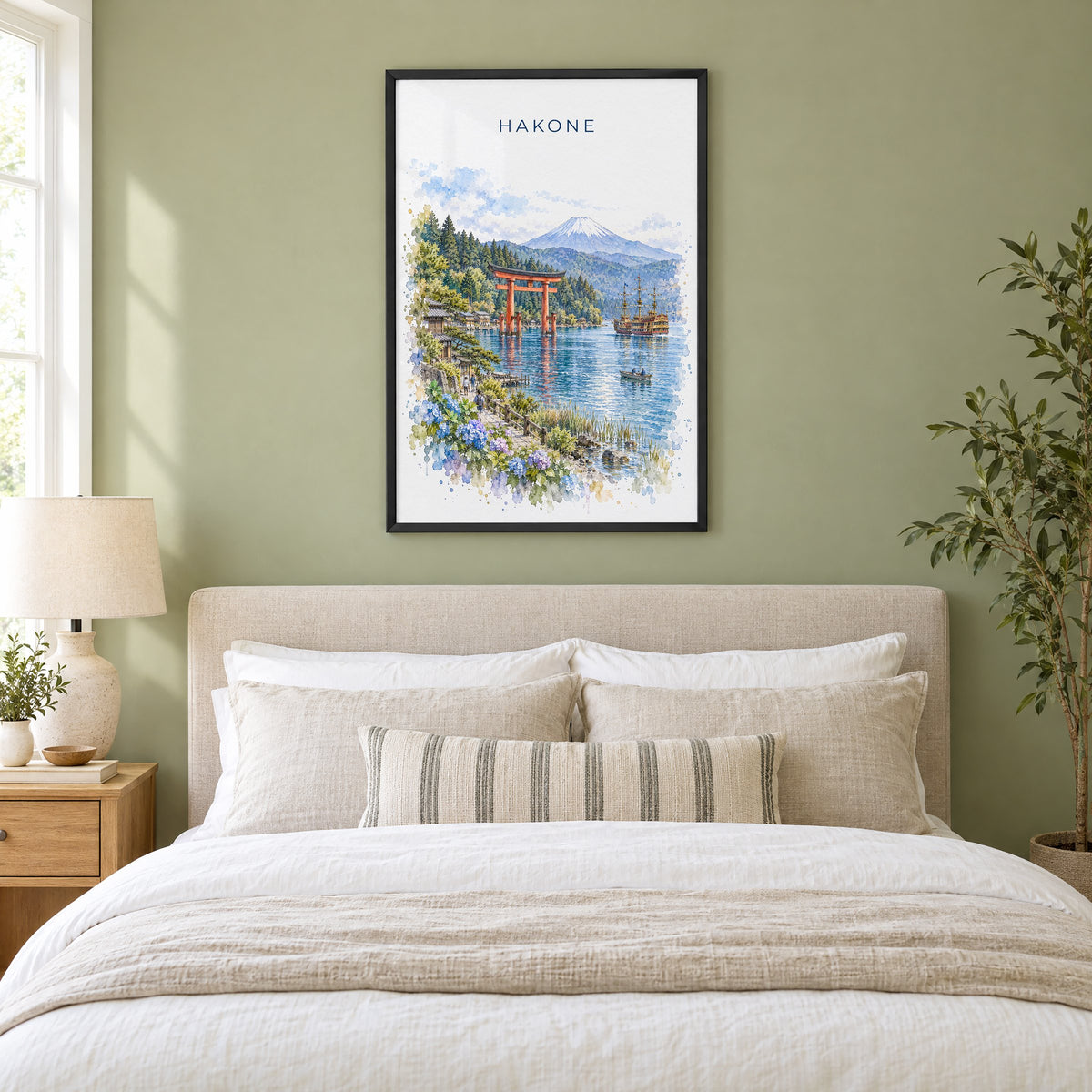 Hakone watercolor print in a black frame above an upholstered headboard in a sage green bedroom