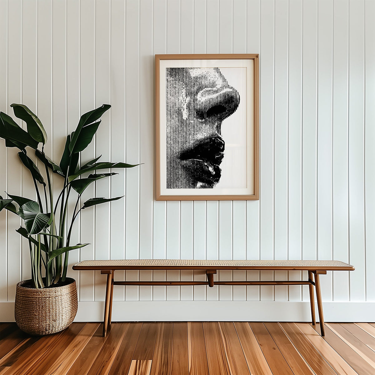 Halftone line face profile graphic print in a wood frame with a white mat above a cane bench