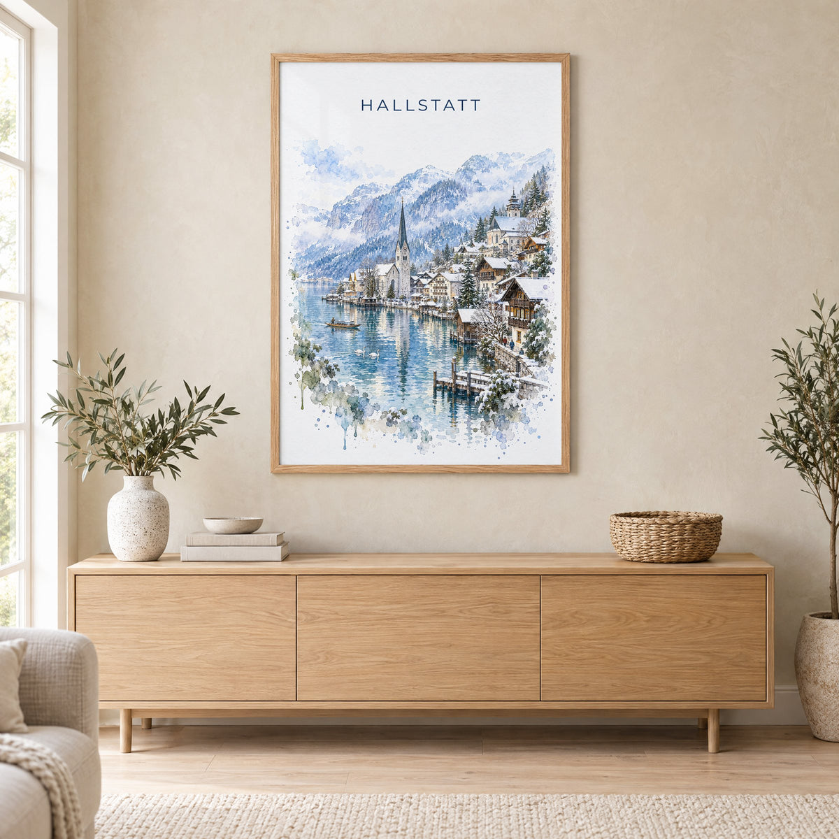 Hallstatt watercolor print in an oak frame above a light wood sideboard in a Scandinavian living room