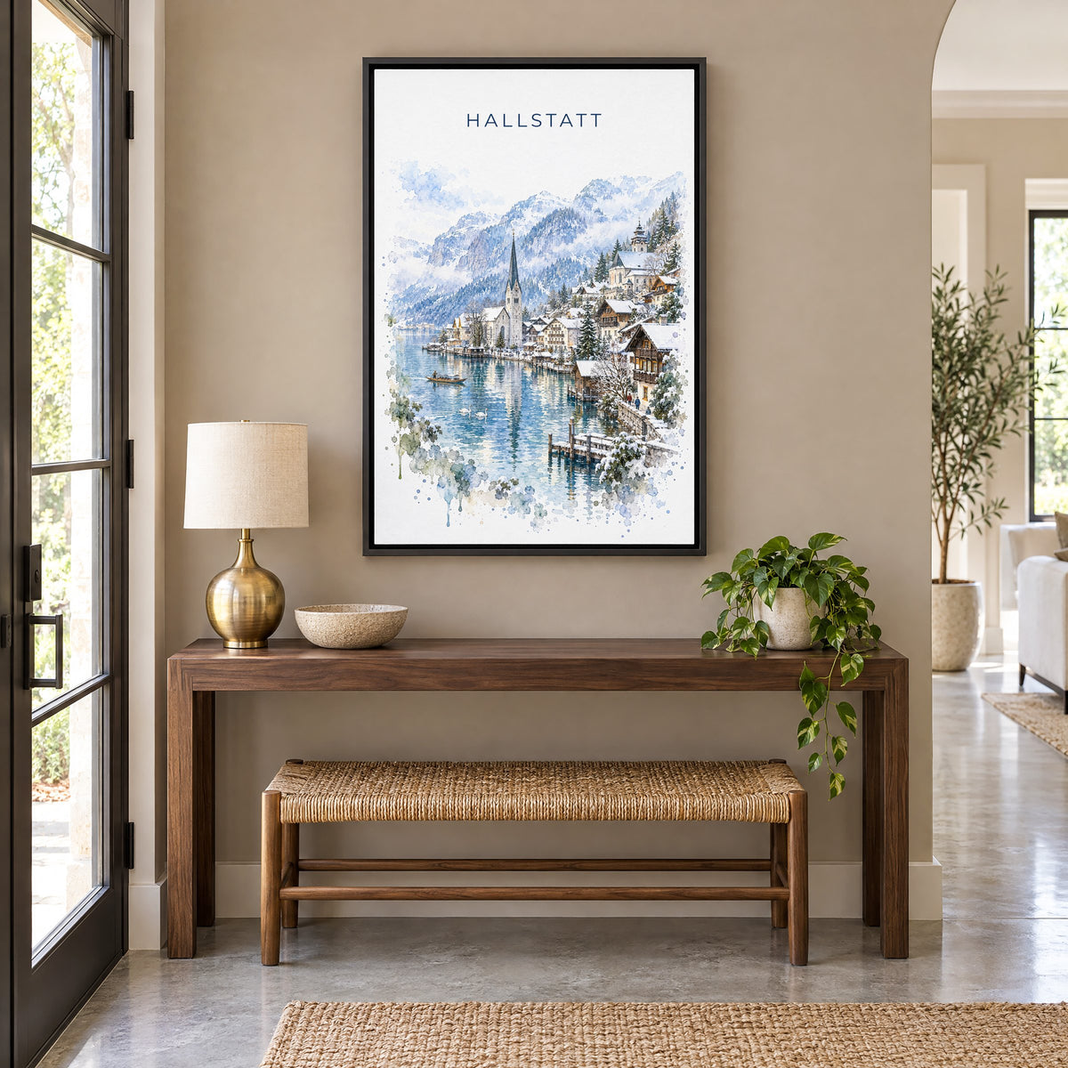 Hallstatt watercolor print as a black floater canvas above a walnut console and woven bench in an entryway