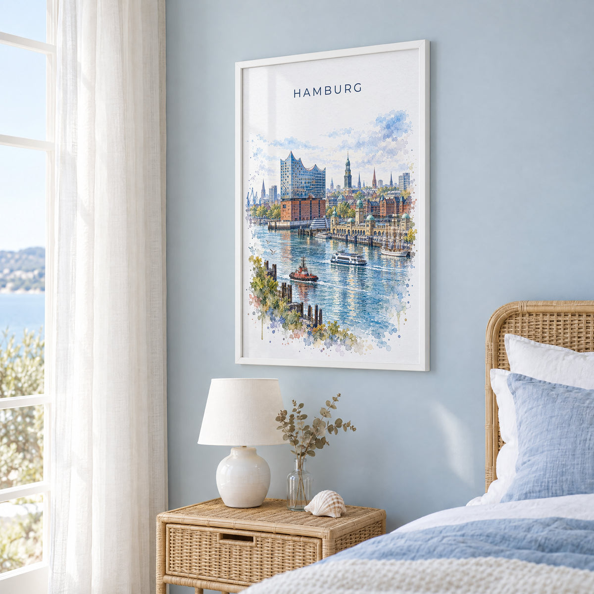Hamburg watercolor print in a white frame on a pale blue wall beside a rattan bed in a coastal bedroom