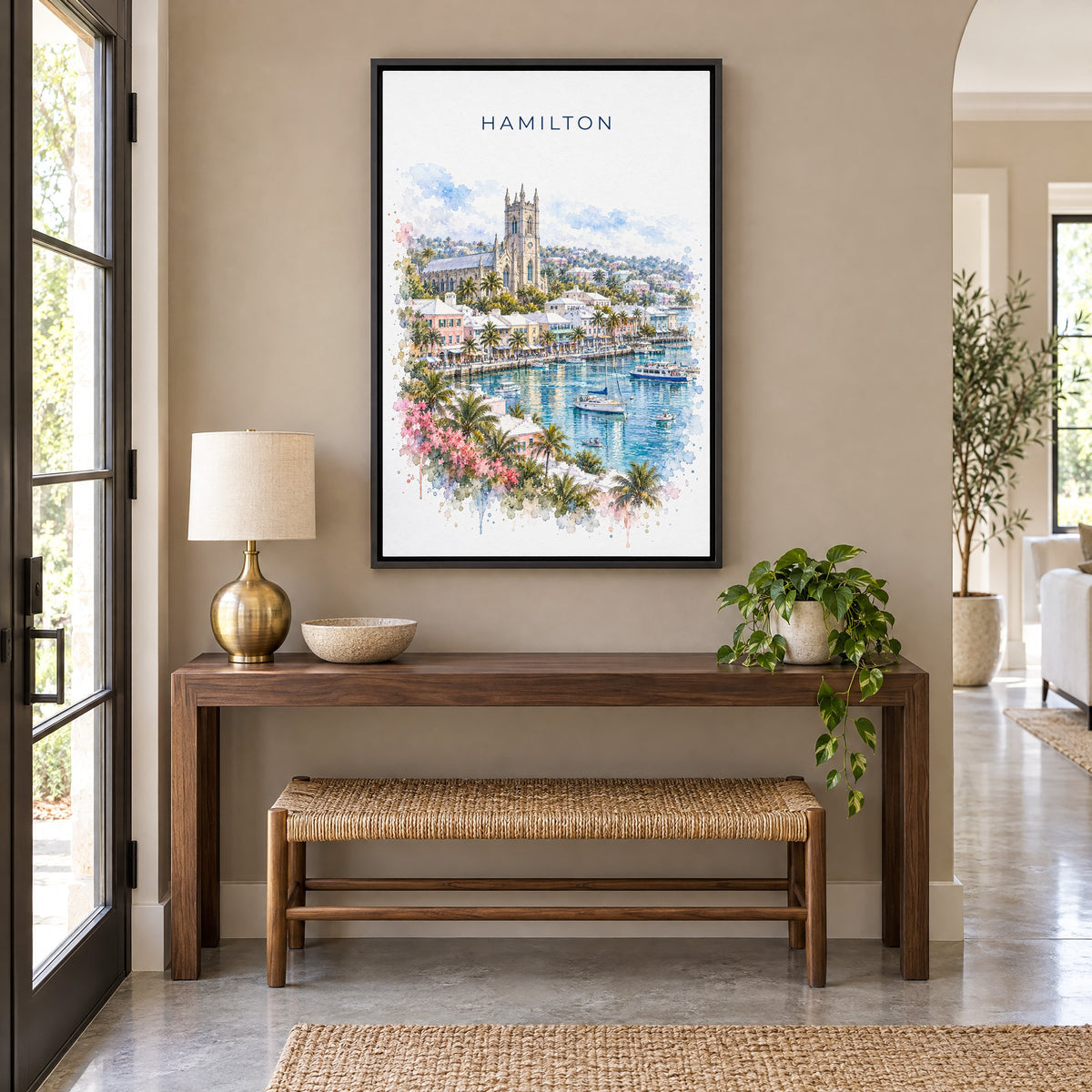 Hamilton, Bermuda watercolor print as a black floater canvas above a walnut console and woven bench in an entryway