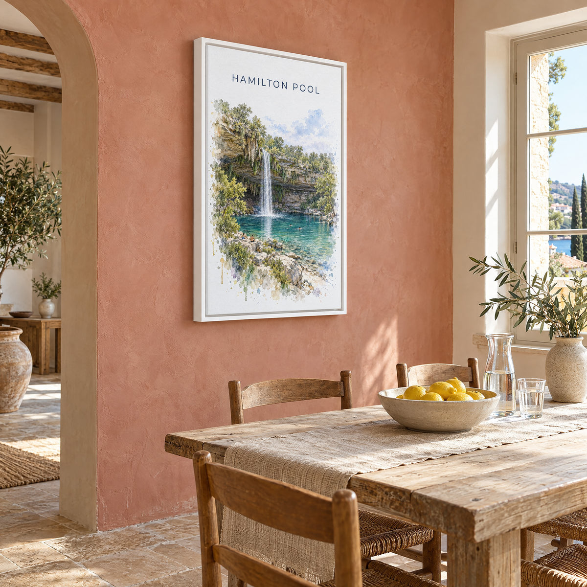 Hamilton Pool watercolor print as a white floater canvas on a terracotta wall above a rustic dining table