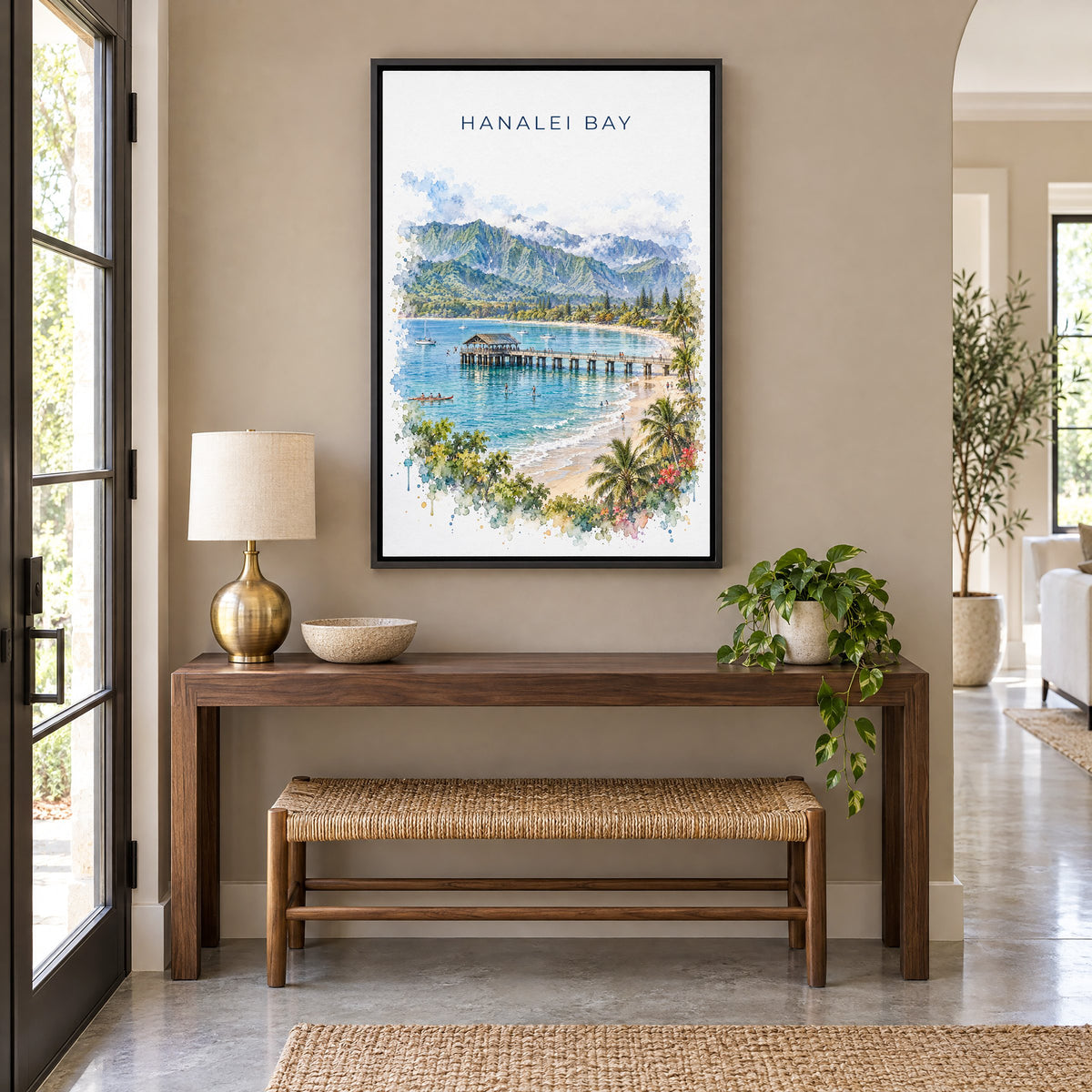 Hanalei Bay watercolor print as a black floater canvas above a walnut console and woven bench in an entryway