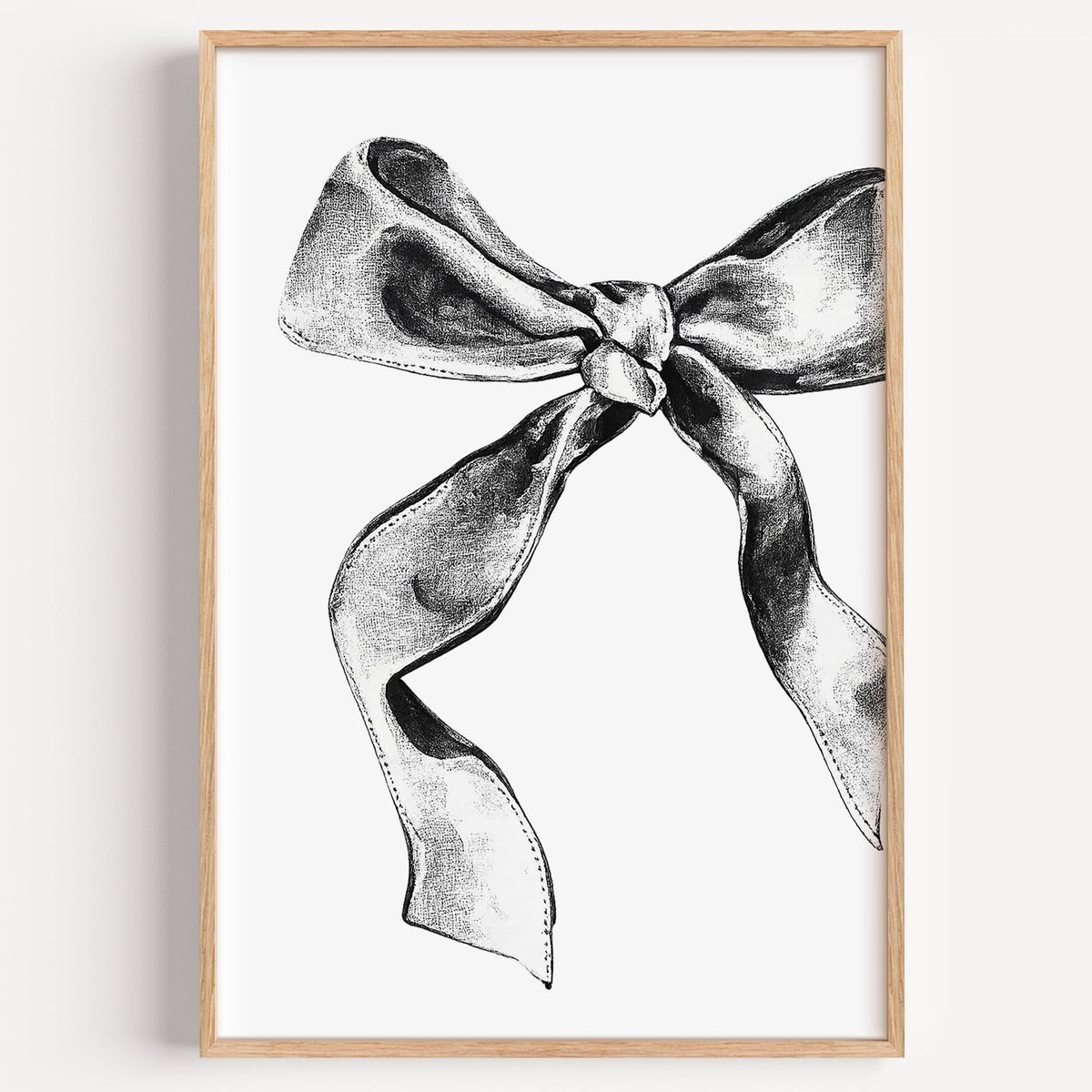 Stippled ink ribbon bow drawing print in a light oak frame on a plain white wall