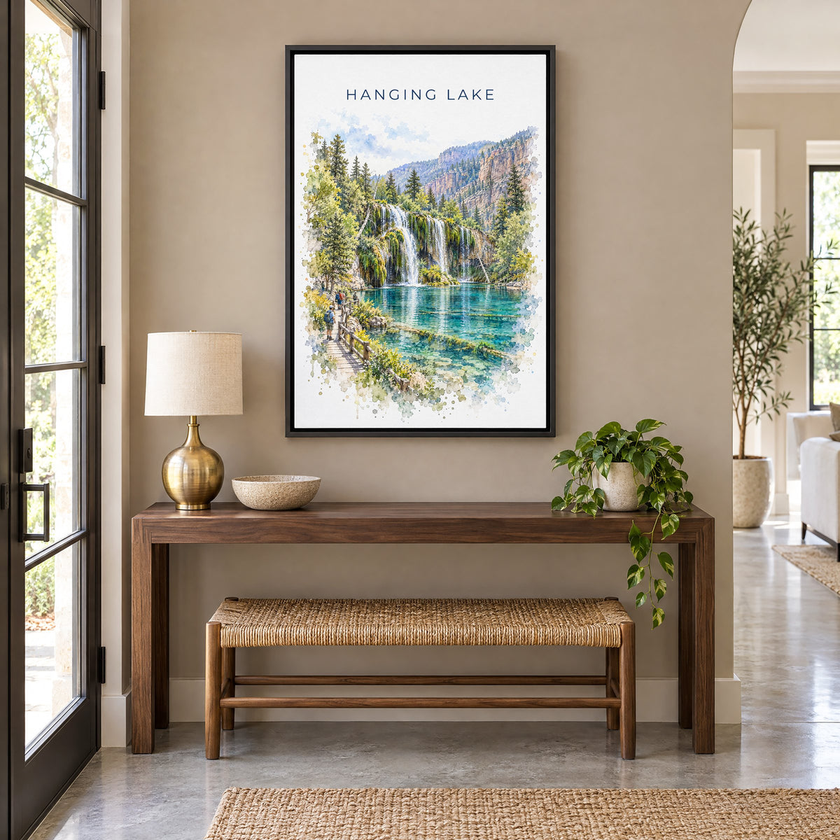 Hanging Lake watercolor print as a black floater canvas above a walnut console and woven bench in an entryway